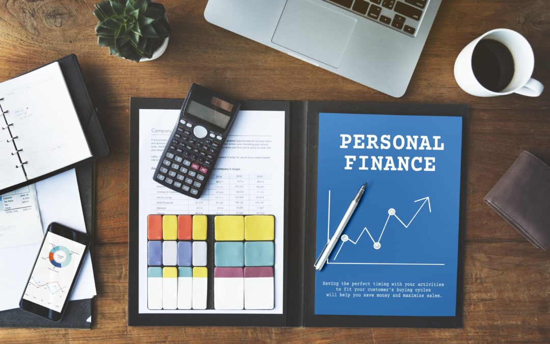 Professional finance files, calculator, smartphone, mug and laptop on a table.